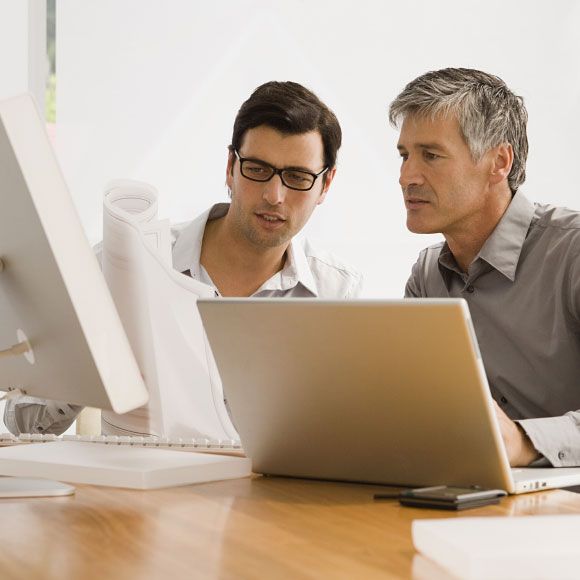 Zwei Berater besprechen am Laptop gemeinsam einen Projektplan
