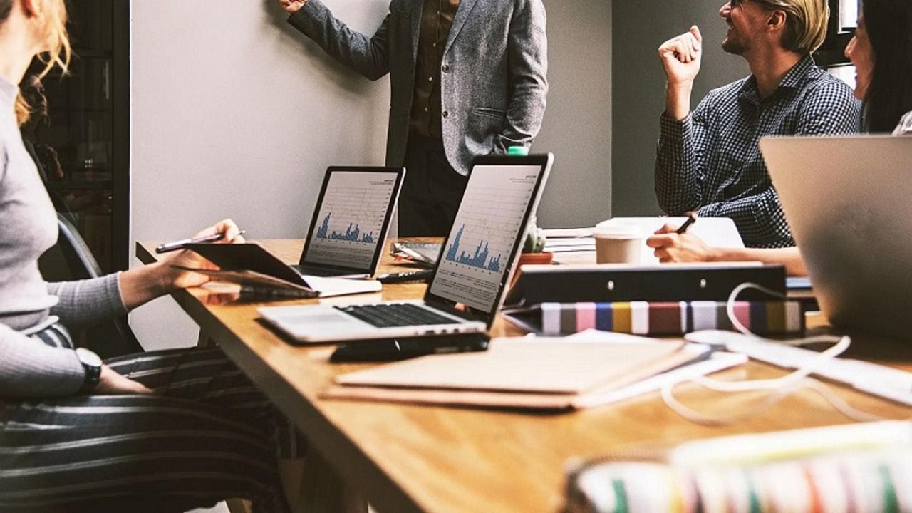 Mehrere Personen arbeiten mit Laptops gemeinsam an einem Besprechungstisch